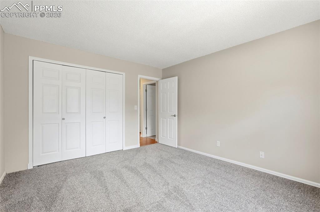 Image 27 of 44: This room features light grey carpeting, neutral-toned walls, and a white b