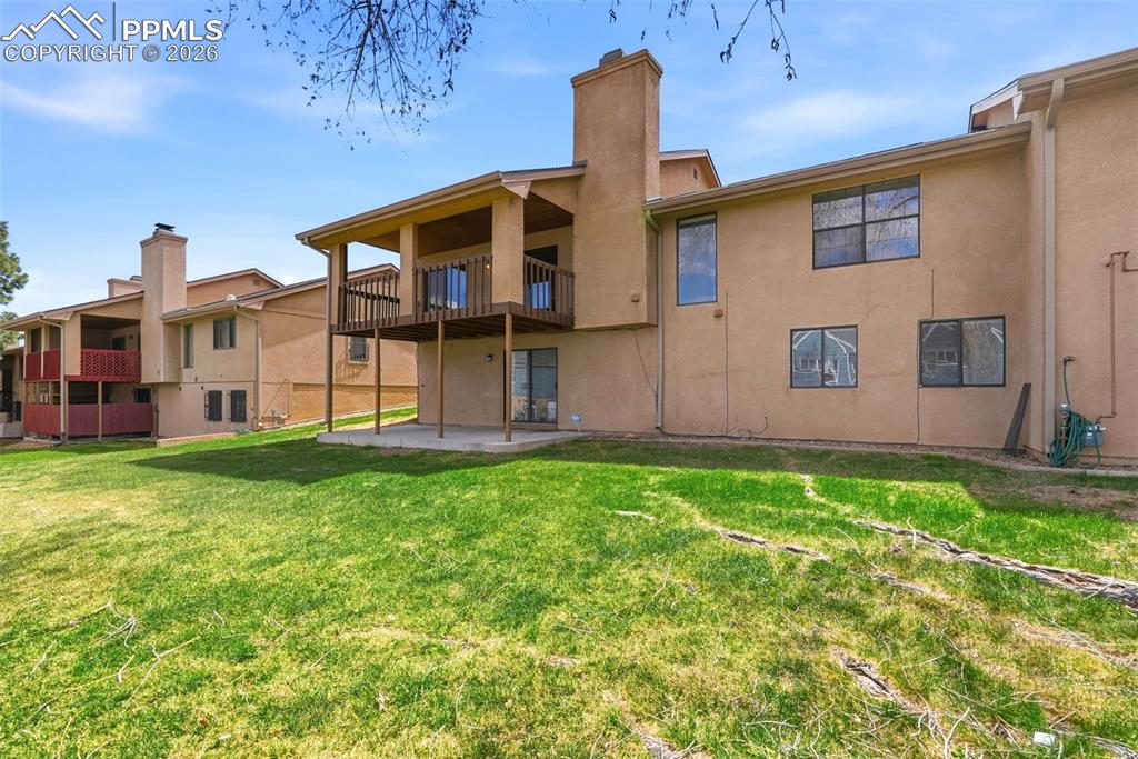 Image 34 of 44: The property features a private yard with a lawn, a ground-level patio, and