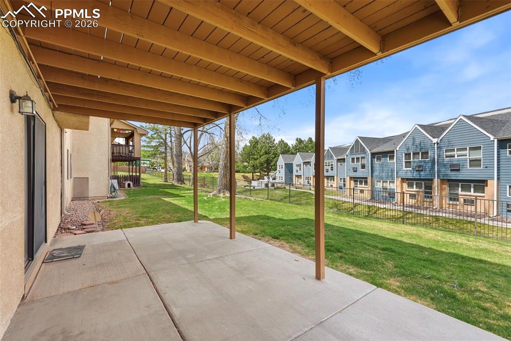 Image 35 of 44: The property includes a covered patio with a concrete surface, offering an 