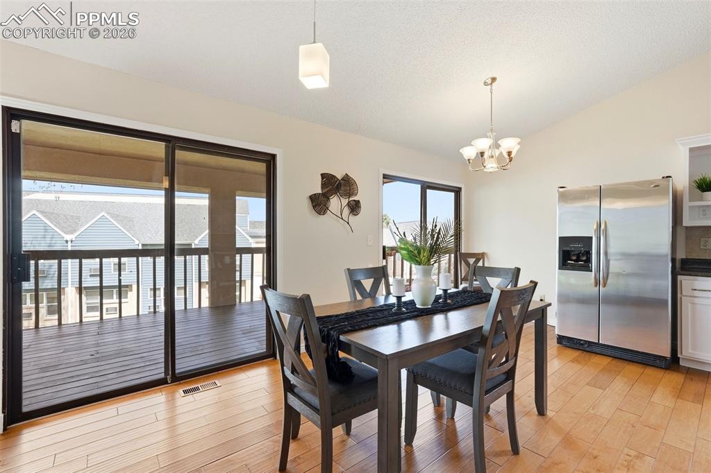 Image 6 of 44: Dining area with hardwood floors, a sliding glass door leading to a deck, a