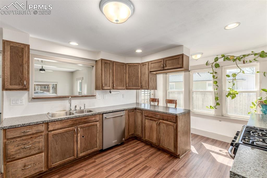 Image 11 of 40: Kitchen with dishwasher, wood finish cabinets, dark wood finished floors, r