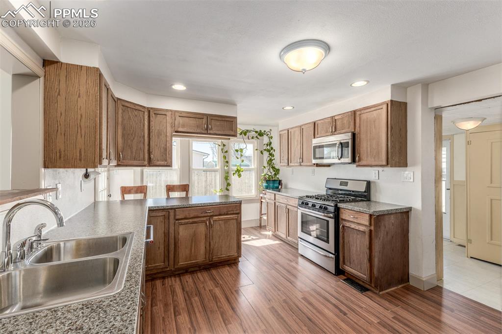 Image 12 of 40: Kitchen with stainless steel appliances, dark wood finished floors, wood fi