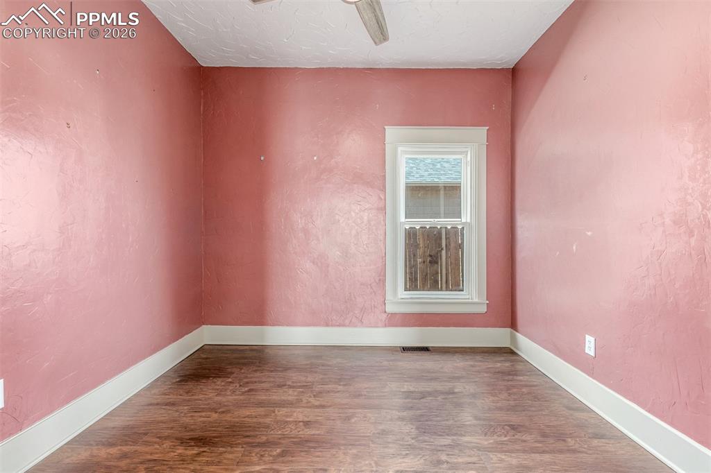 Image 14 of 40: Unfurnished room featuring dark wood-style floors, a textured wall, ceiling