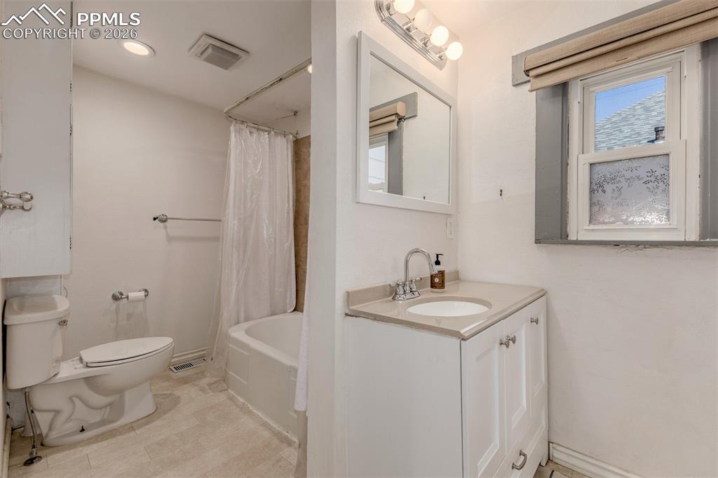 Image 16 of 40: Bathroom with vanity and shower / bathtub combination with curtain