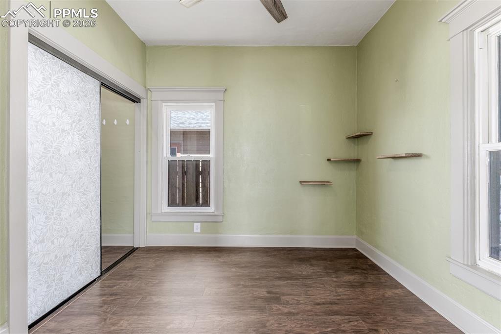Image 17 of 40: Spare room featuring dark wood-type flooring and a ceiling fan