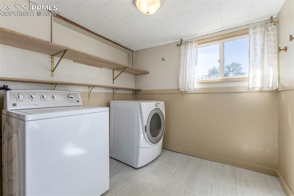 Image 21 of 40: Laundry room featuring washer and clothes dryer and baseboards