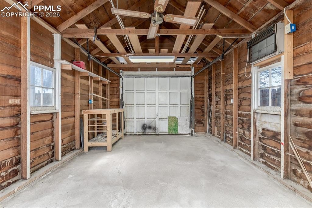 Image 23 of 40: Garage with wooden ceiling and wood walls