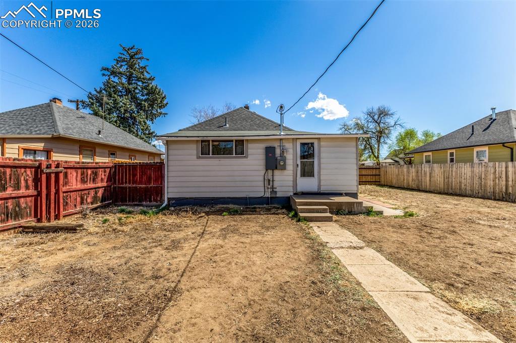 Image 26 of 40: Rear view of house featuring a fenced backyard
