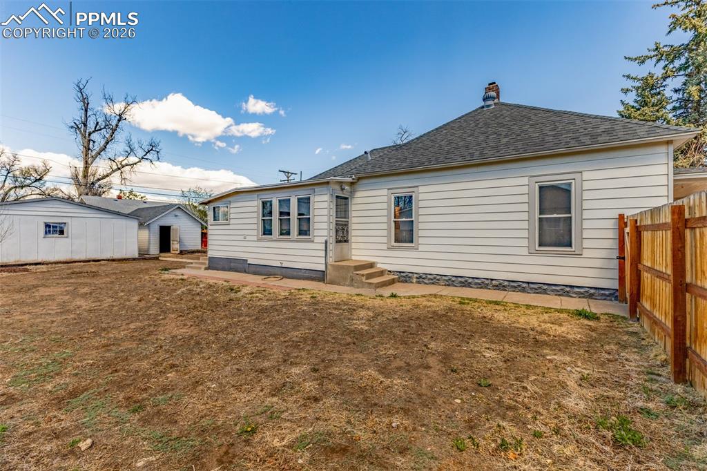 Image 29 of 40: Back of house with a chimney and a shingled roof