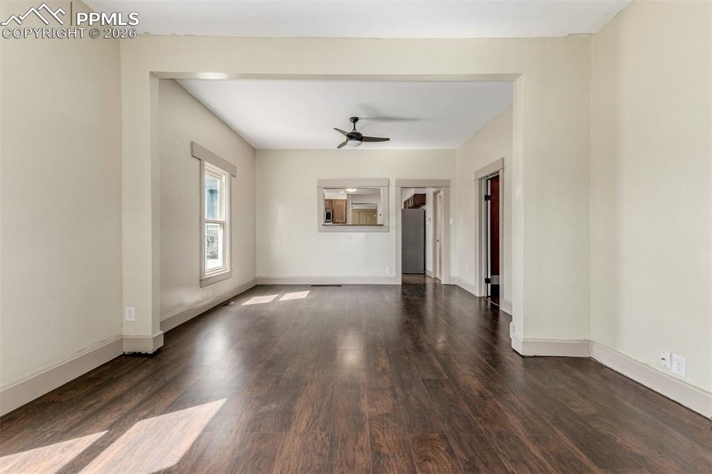 Image 6 of 40: Unfurnished living room with dark wood-type flooring and a ceiling fan