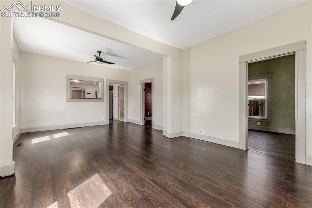 Image 7 of 40: Spare room featuring ceiling fan and dark wood-style flooring