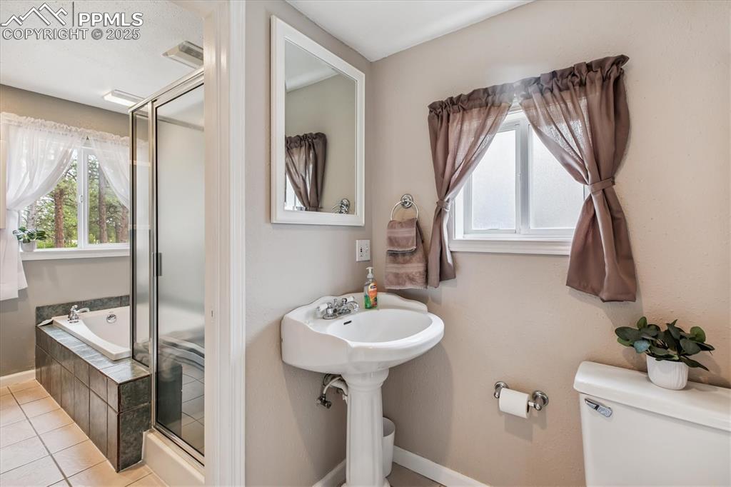 Image 15 of 29: Full bath with a stall shower, a bath, and tile patterned floors