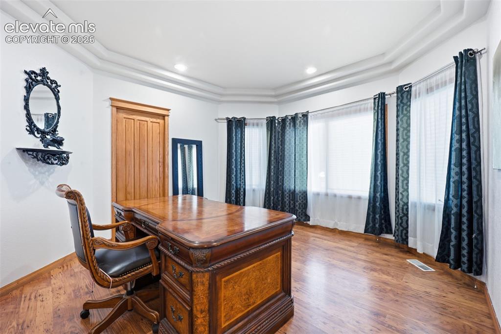 Image 11 of 49: Curved bay windows, recessed ceiling lighting, wood-finish flooring, and a