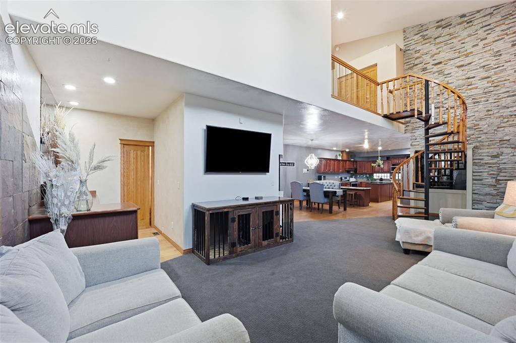 Image 19 of 49: High ceilings, spiral staircase with wood treads, stone accent wall, wood-f