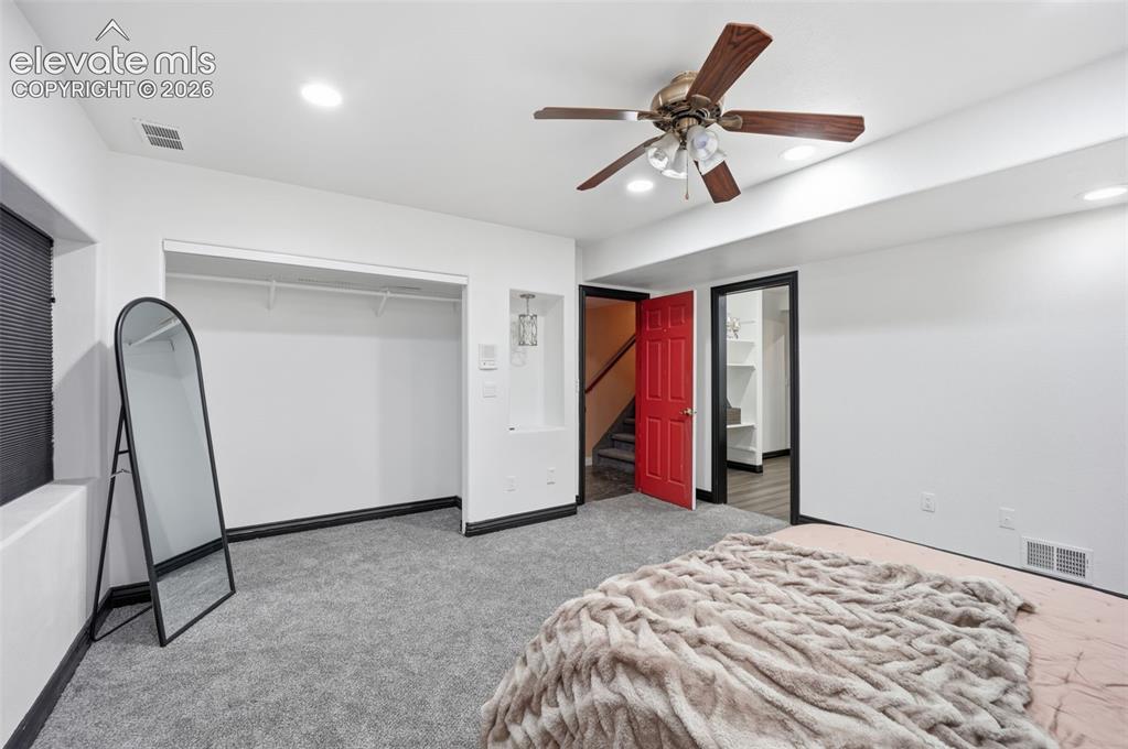 Image 21 of 49: Plush gray carpeting, white walls, and a ceiling fan with integrated lighti
