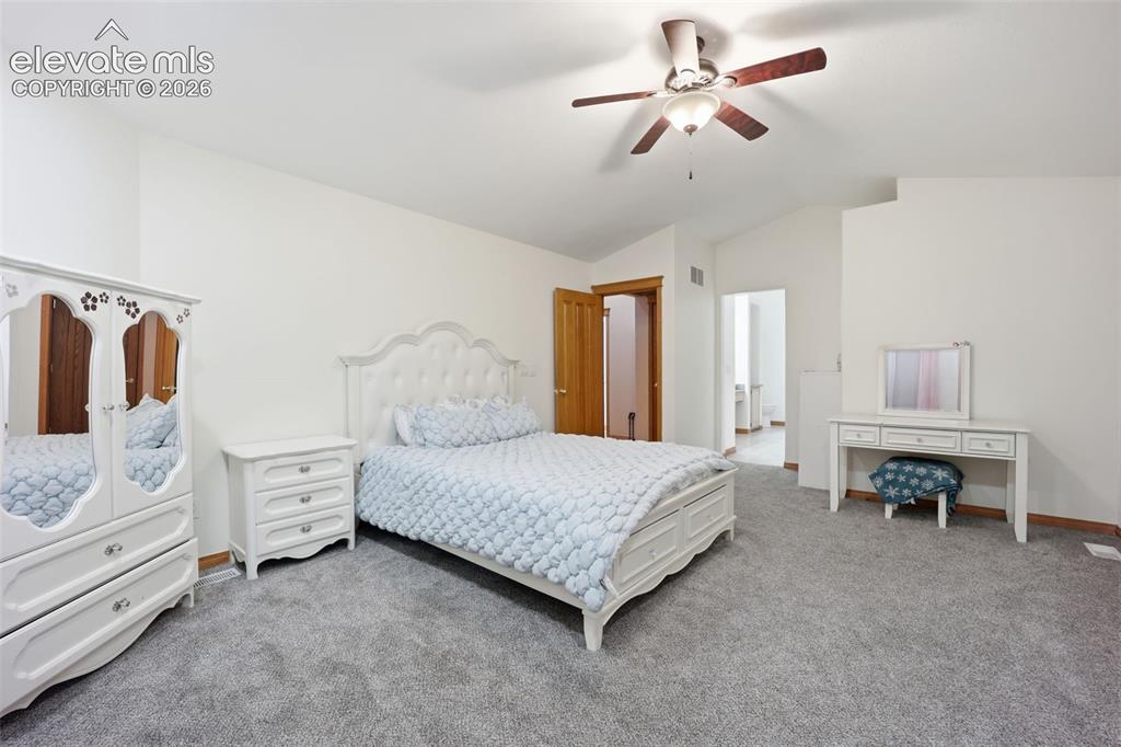 Image 34 of 49: Vaulted ceilings with a ceiling fan, light gray carpet, and wood-finish doo