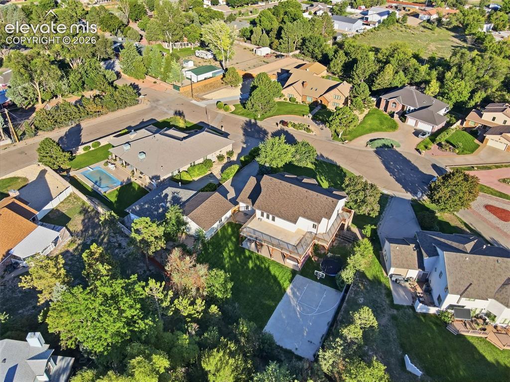 Image 46 of 49: Expansive property with a basketball court, mature trees, and a multi-level