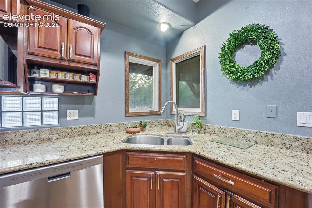Image 5 of 49: Stainless steel double basin sink, light-toned countertops, and wood-finish