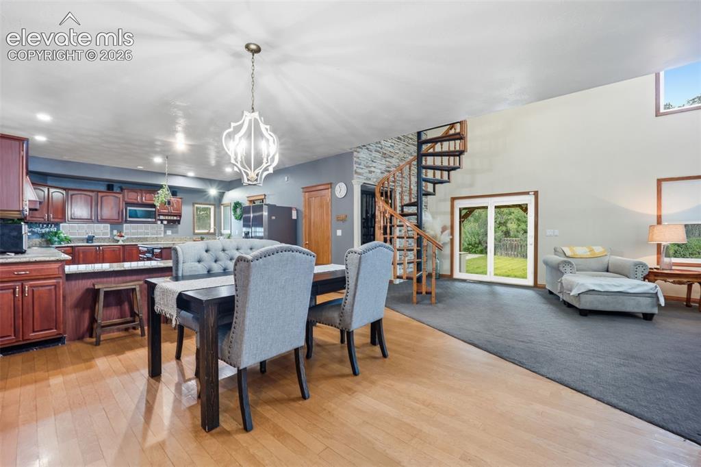 Image 8 of 49: Wood-finish flooring, cherry wood cabinetry with stone countertops, a spira