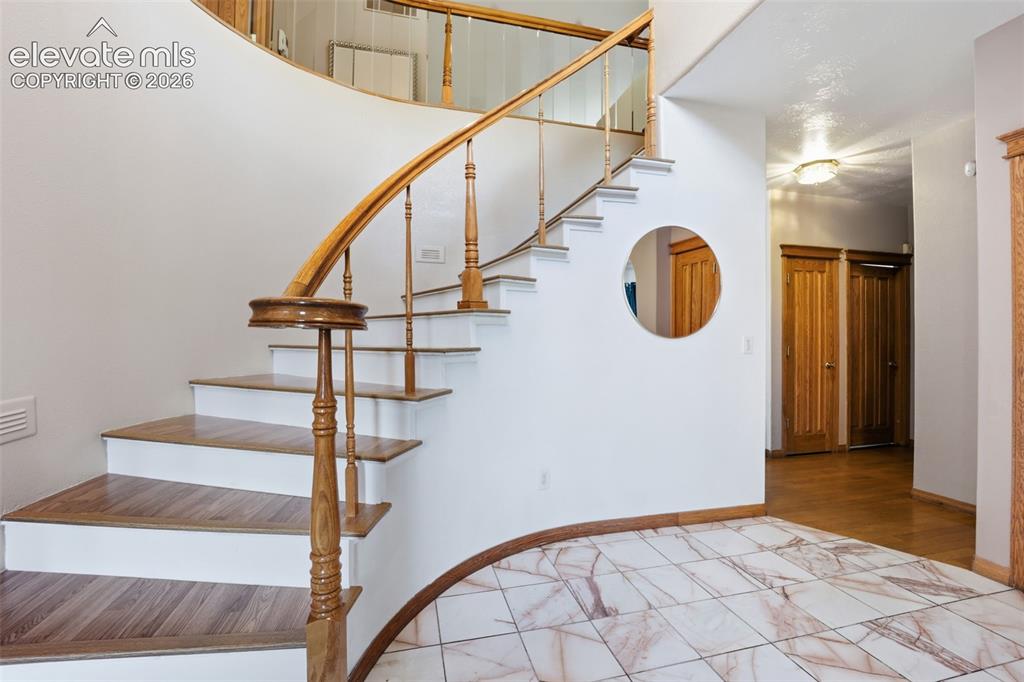 Image 9 of 49: Curved staircase with wood-finish treads and balusters
