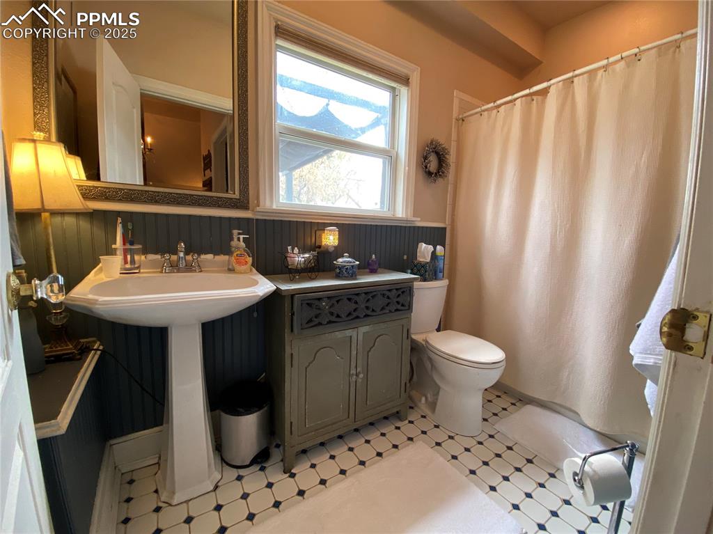 Image 20 of 36: The FULL bath has custom tile flooring and a historically preserved cabinet