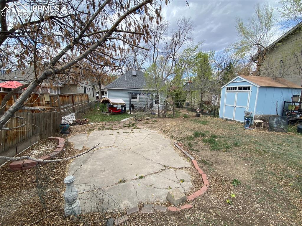 Image 27 of 36: The fully fenced backyard has several useful spaces