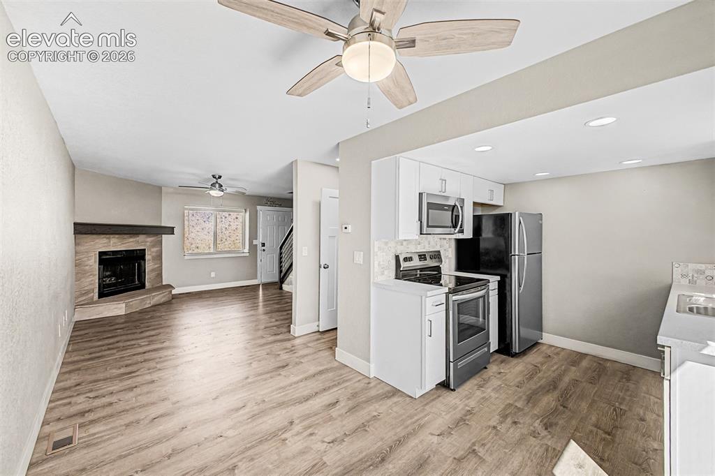 Image 10 of 31: Wood-finish flooring throughout, complemented by a stone-clad fireplace wit