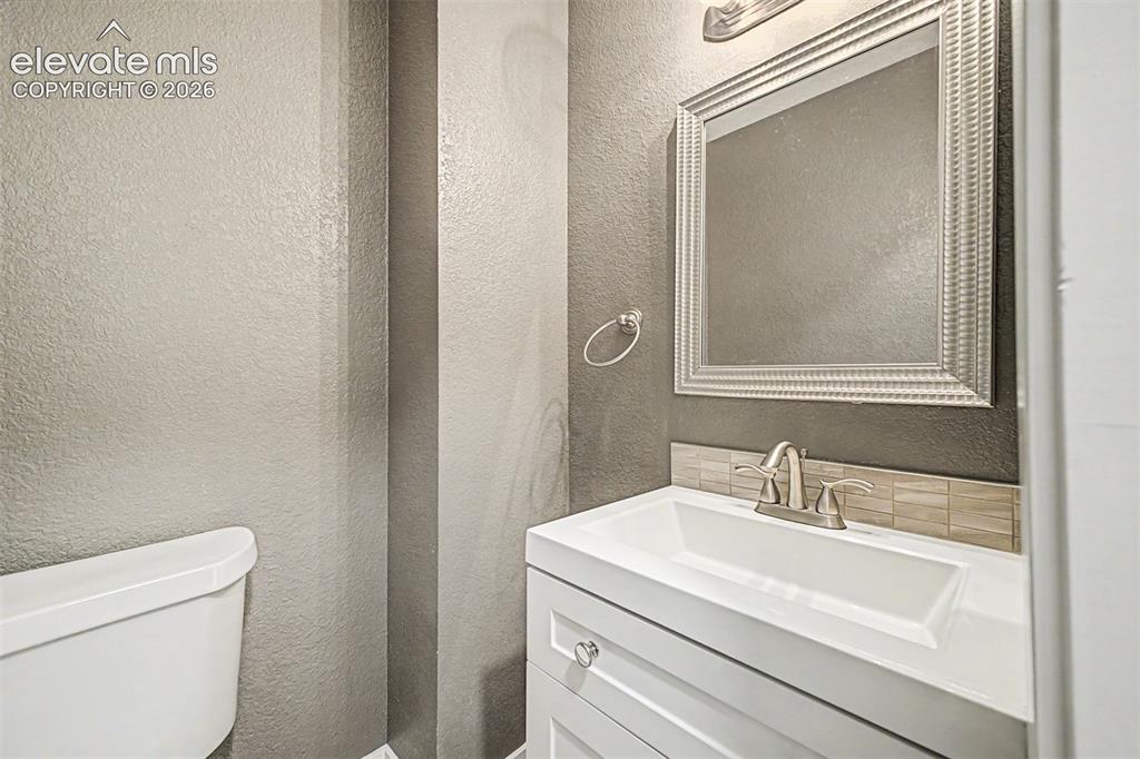 Image 15 of 31: White vanity with silver-finish hardware, rectangular integrated sink, and 