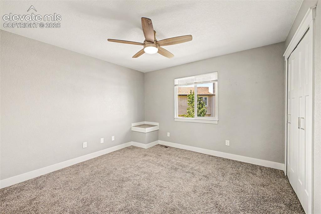 Image 16 of 31: Textured carpeting, neutral paint palette, ceiling fan with integrated ligh