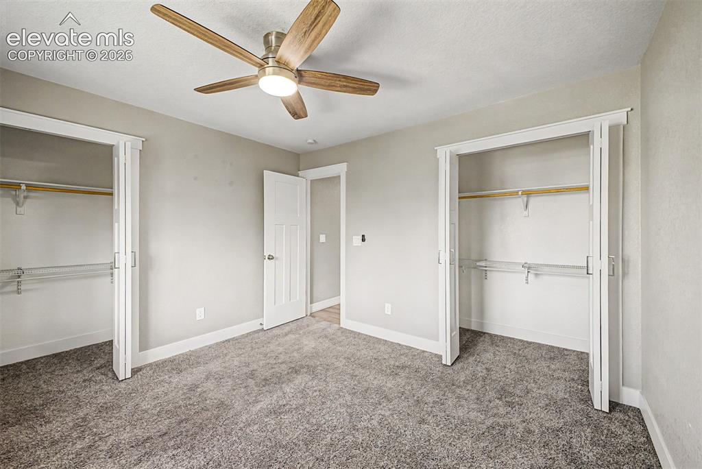 Image 18 of 31: Plush carpeted flooring, two bi-fold door closets with wire shelving, moder