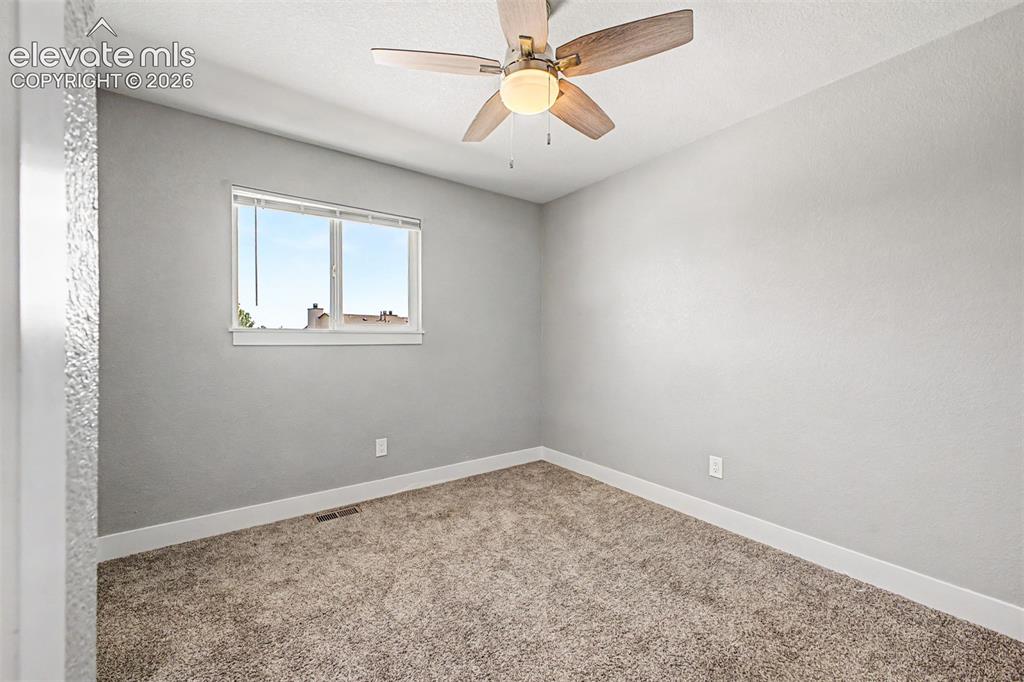 Image 19 of 31: Carpeted flooring with a ceiling fan light fixture, a window with blinds, a