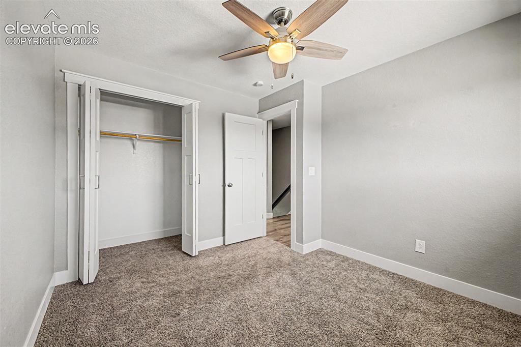 Image 21 of 31: Carpeted room featuring a ceiling fan with integrated lighting, bi-fold clo
