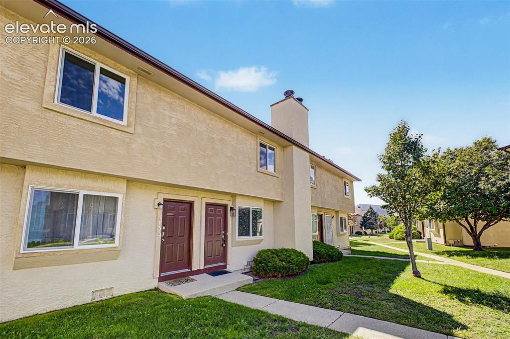 Image 3 of 31: Stucco exterior featuring dual entry doors, multiple windows, and a promine