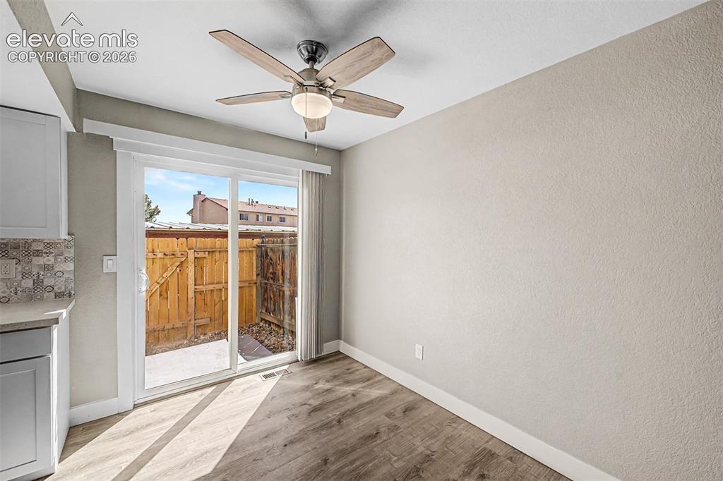 Image 9 of 31: Wood-finish flooring, sliding glass door, modern ceiling fan with light fix