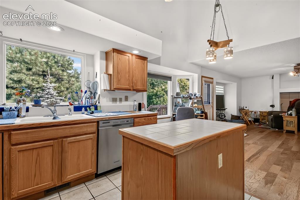 Image 9 of 41: Tile Countertops and Ceramic Tile Floors in Kitchen