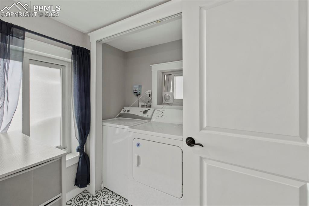 Image 21 of 27: Washroom featuring washing machine and clothes dryer