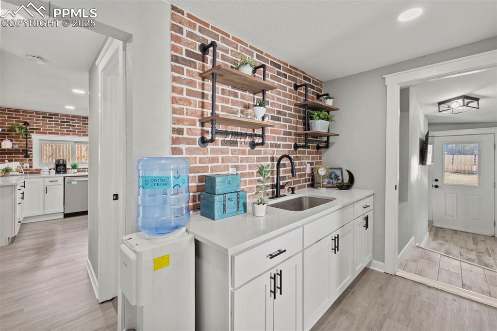 Image 22 of 27: Butlers pantry with brick wall