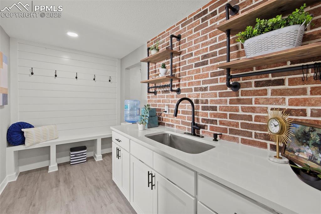 Image 4 of 27: Mudroom and butlers pantry with brick wall