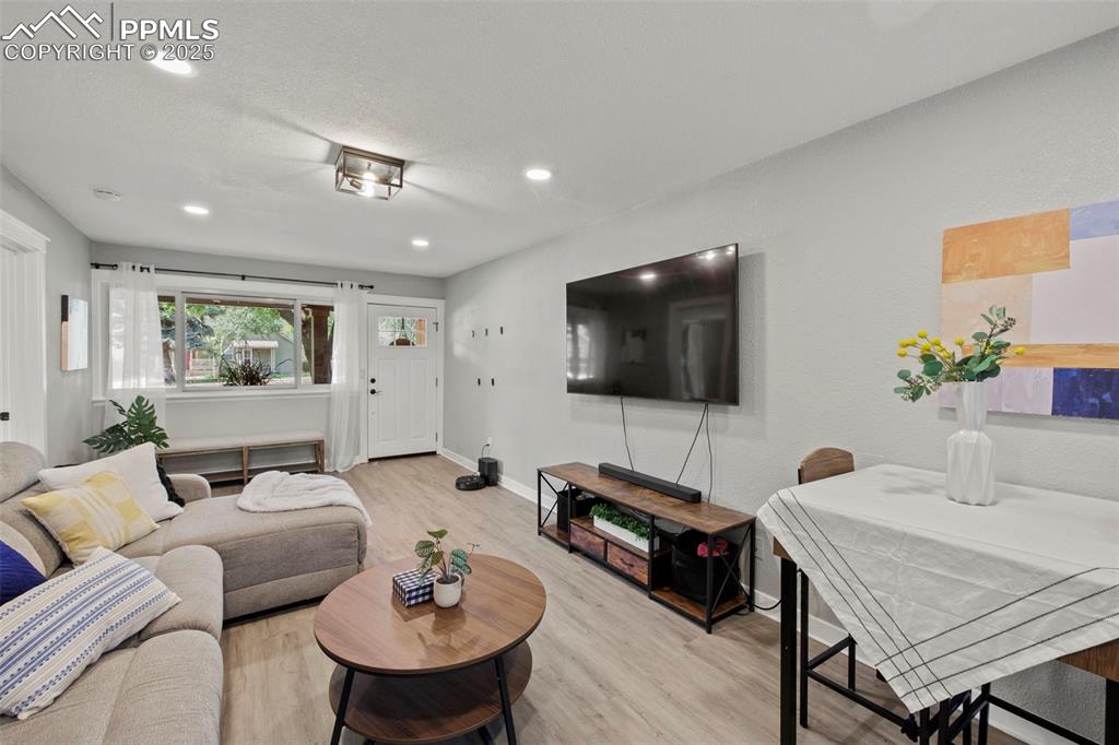 Image 6 of 27: Living area featuring light wood-type flooring and recessed lighting