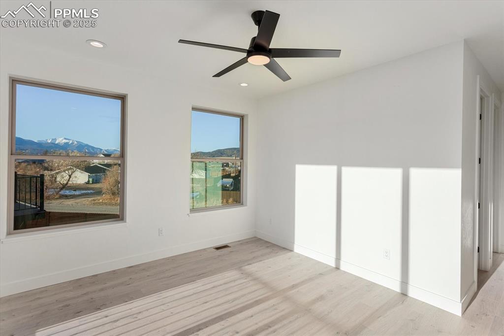 Image 15 of 30: Unfurnished bedroom featuring a mountain view, light hardwood / wood-style