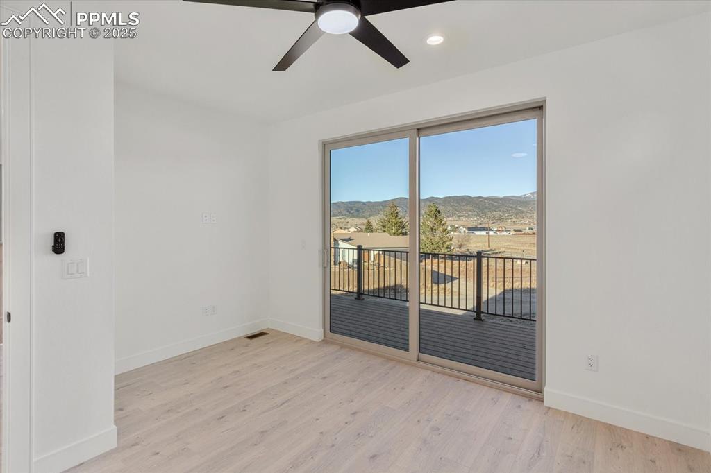 Image 19 of 30: Spare room with a mountain view, ceiling fan, and light hardwood / wood-sty