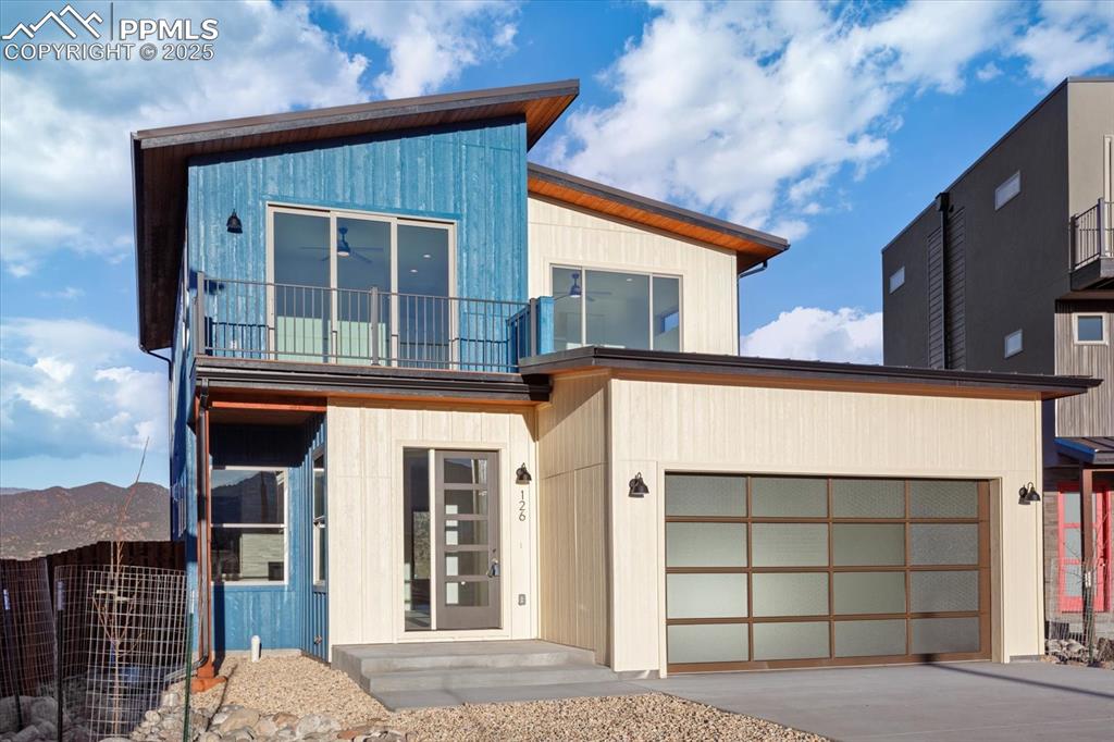Image 2 of 30: Contemporary house with a mountain view, a balcony, and a garage