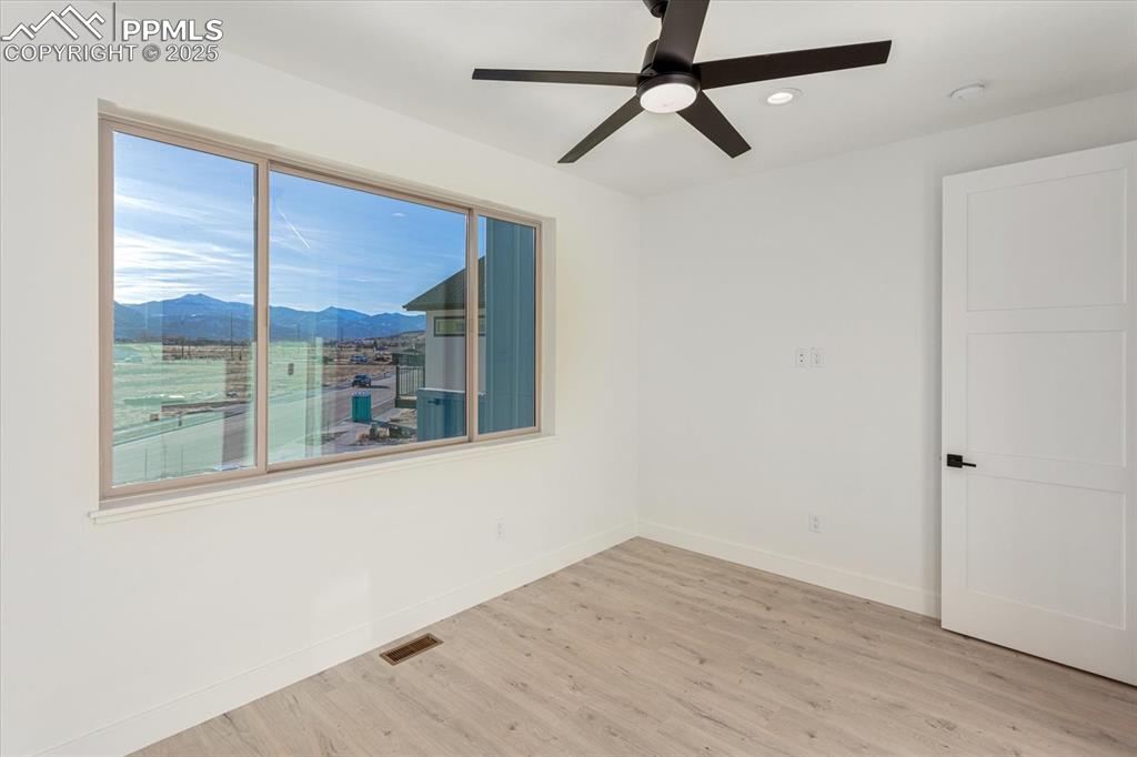 Image 20 of 30: Empty room featuring a mountain view, light hardwood / wood-style floors, a