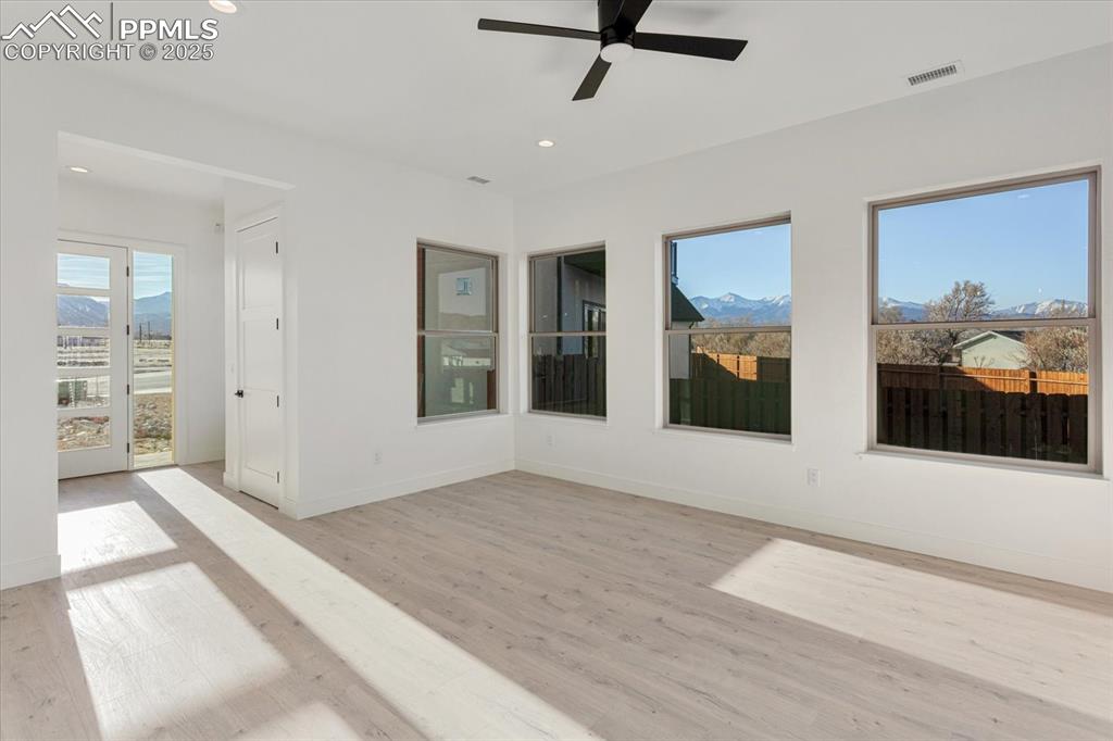 Image 5 of 30: Empty room featuring a mountain view, light hardwood / wood-style floors, a