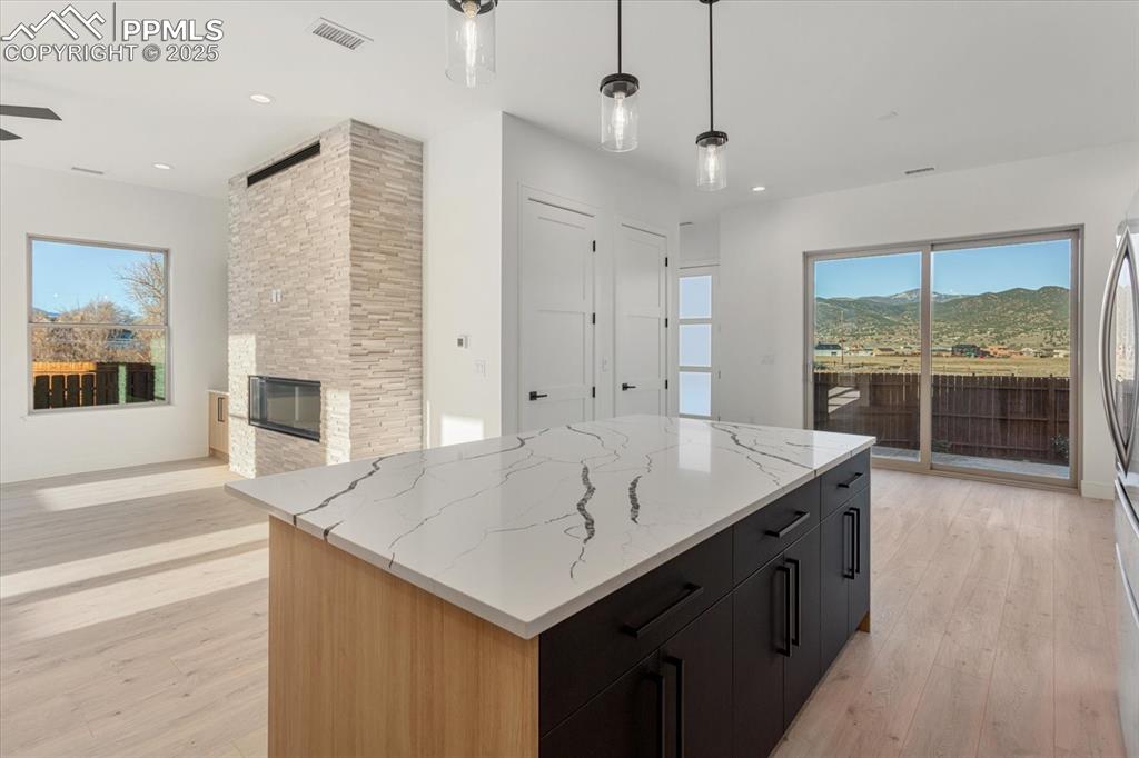 Image 9 of 30: Kitchen featuring pendant lighting, light hardwood / wood-style flooring, a
