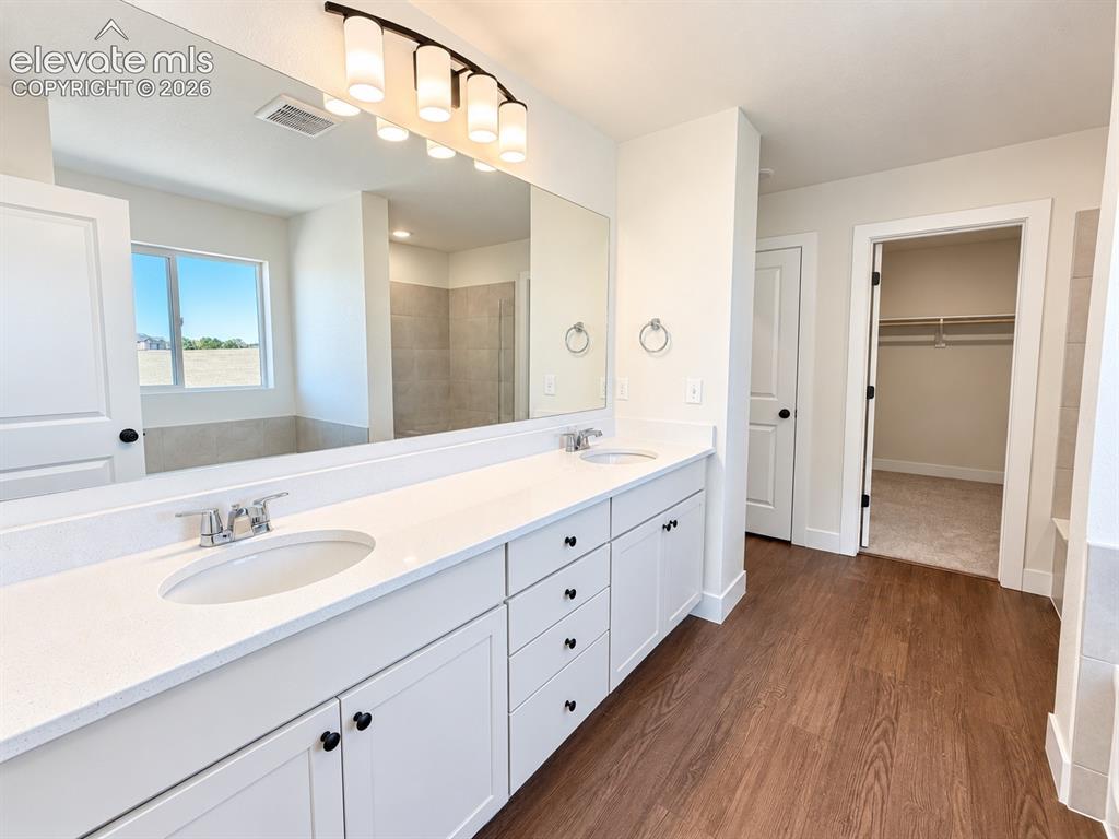 Image 13 of 26: Dual vanity with white cabinetry and integrated sinks