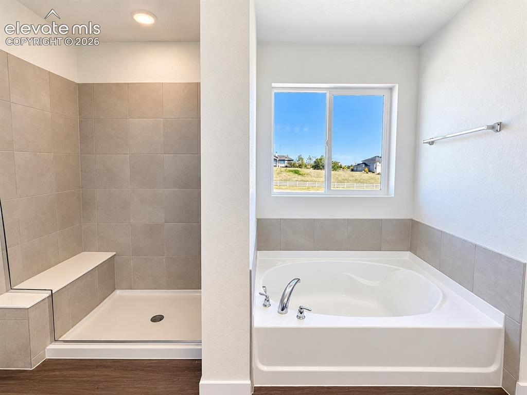 Image 14 of 26: Spacious bathroom featuring a built-in soaking tub, separate walk-in shower