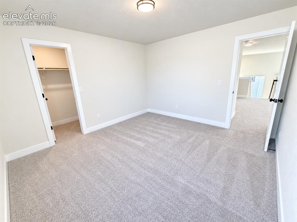 Image 16 of 26: Neutral-toned wall paint and carpeting throughout the space