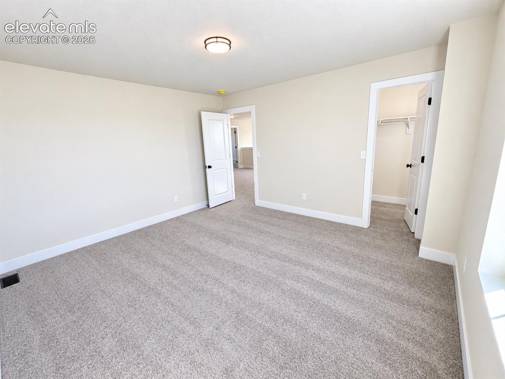 Image 17 of 26: Neutral tone wall paint, light-colored carpeting, white trim, flush mount c