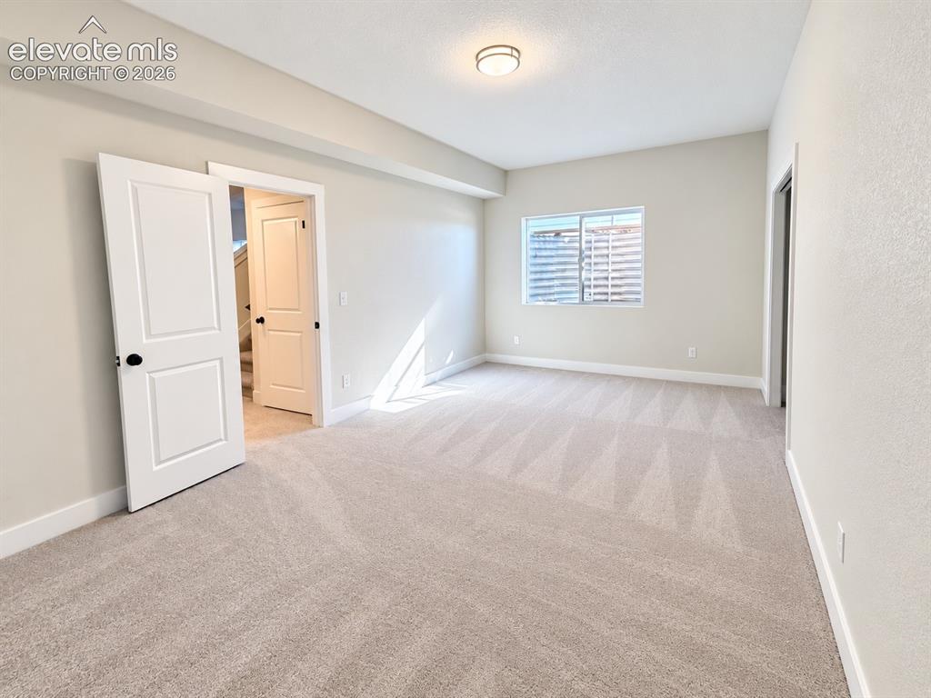 Image 22 of 26: Neutral-toned walls and plush carpet flooring